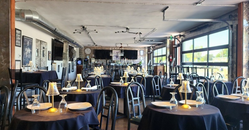 The dining area with set tables, wall art, and large windows