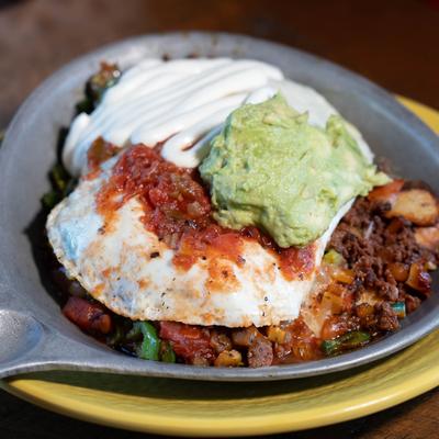 Mexican Skillet, with sausage, tomato, onion, jalapenos, cheese, guacamole, and salsa.