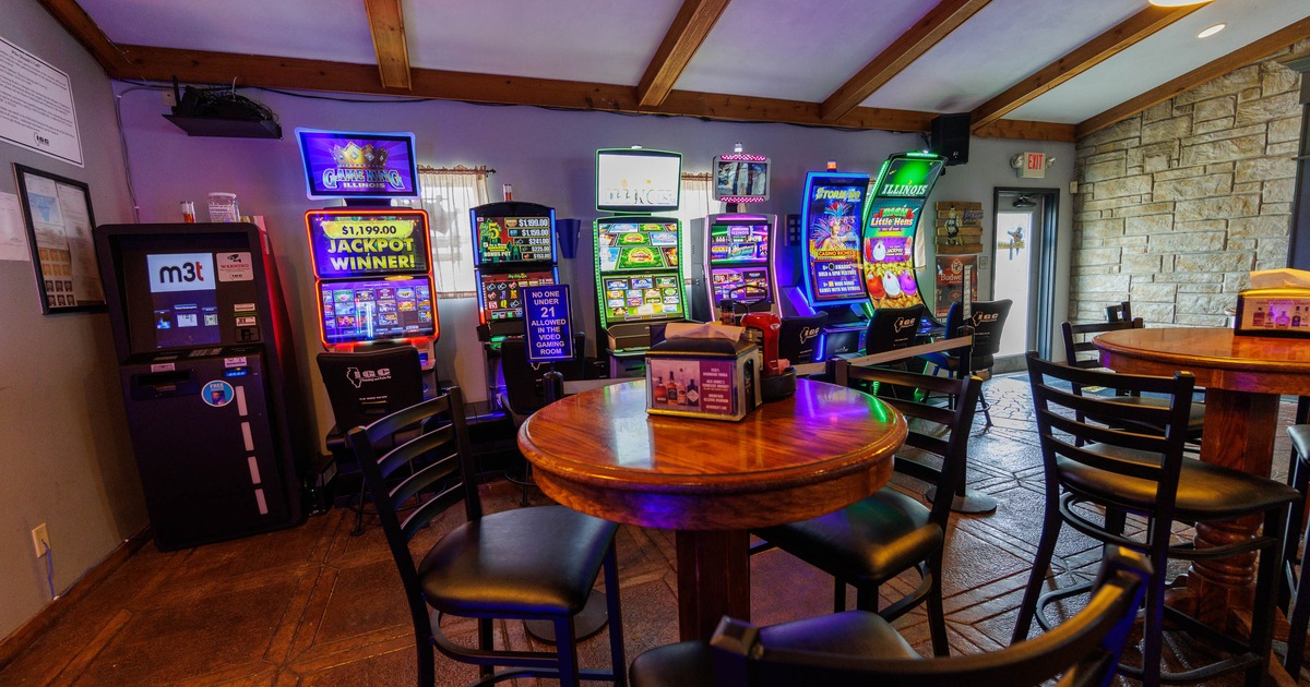 Entertainment space with slot machines, a wooden table, and chairs