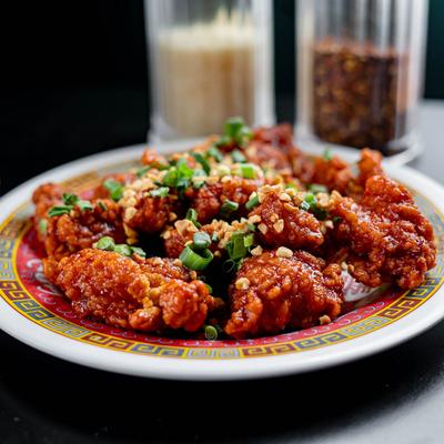 Boneless wings in gochujang sauce with crushed peanuts and green onion.