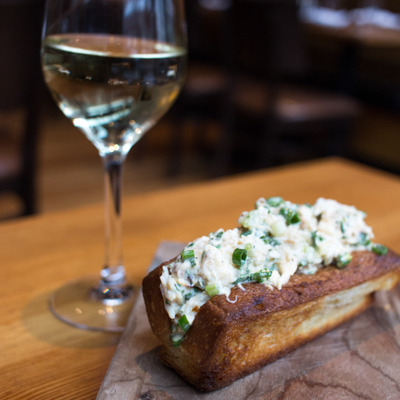 Dungeness Crab Roll  with bun, tabasco mayo, celery, a glass of white wine
