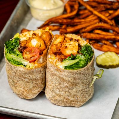 Buffalo Chicken Wrap served ewith sweet potato fries and a dipping sauce.