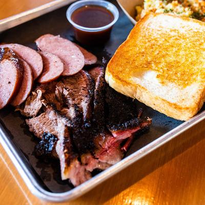 Three Meat Plate with brisket, turkey breast, pulled pork, toast,coleslaw, and sauce.