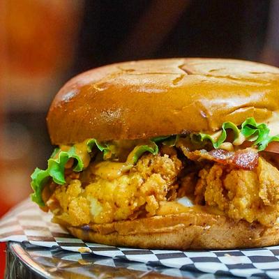 Fried chicken sandwich with bacon, and lettuce.