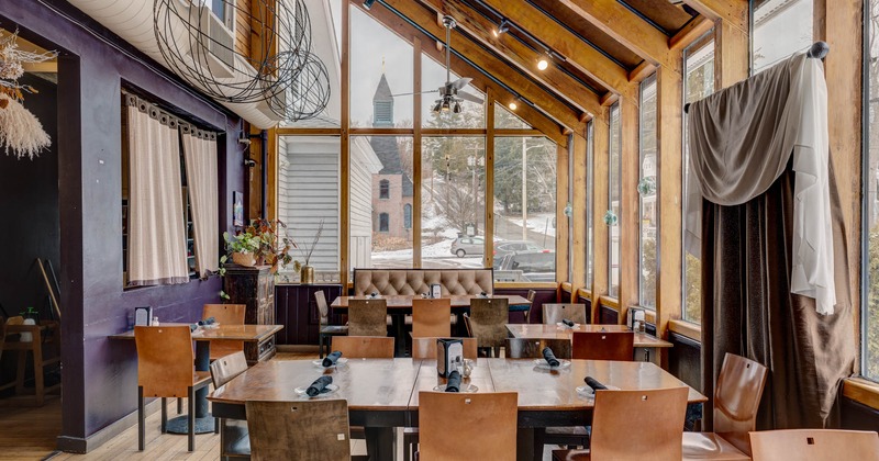 Interior, tables, chairs and high back benches next to the windows