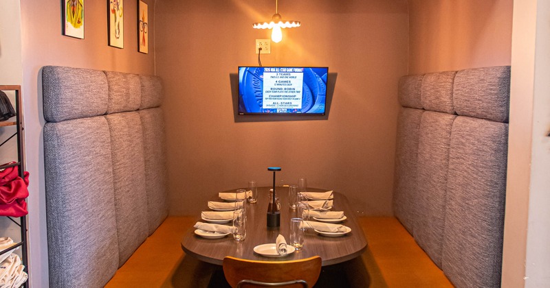 Restaurant booth with gray benches, yellow cushions, wooden table set for six