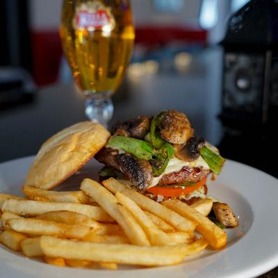 Papagallo Burger with tomatoes, pickles, green beans, mushrooms, Swiss cheese and fries