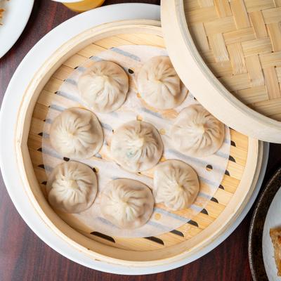 Pork Soup Dumplings served in a bamboo steamer.