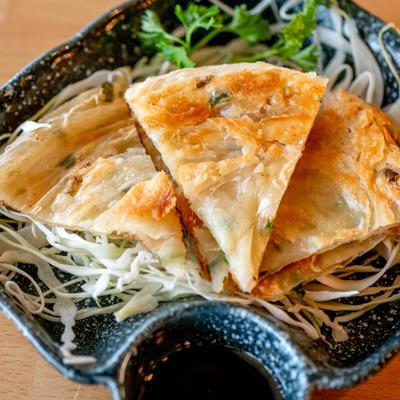 Scallion Pancake sliced and served on abed of shreded cabage.