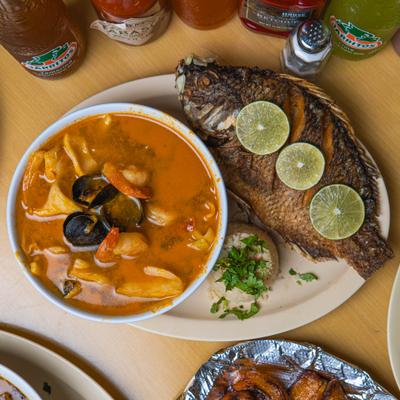 Seafood soup served with whole fish and lime.
