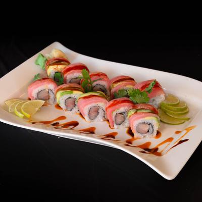 Sushi rolls with red snapper, tuna, and avocado on a plate with citrus.