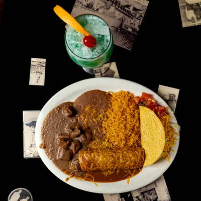 Smothered burrito, taco, beef chunks, salsa, rice, and refried beans.