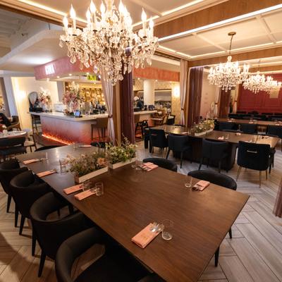 Elegant dining room with crystal chandeliers, dark wood tables, and modern seating.