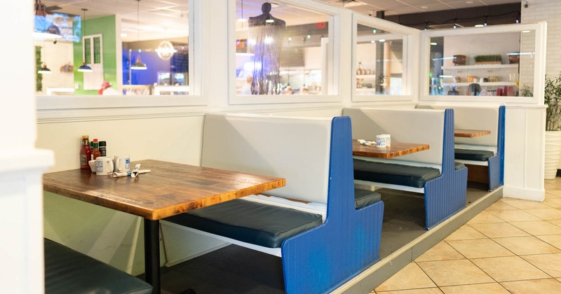 Interior, seating booths with wooden top tables, condiments on the table