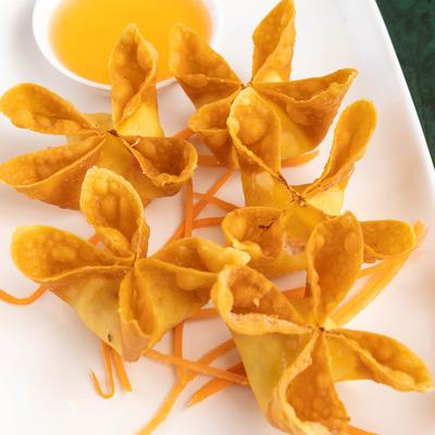 Crab Rangoon served with sweet and sour sauce.