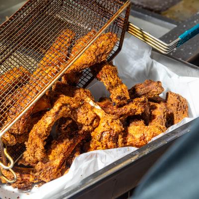 Basket of freshly fried chicken pieces.