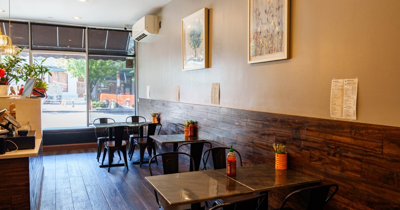 Interior, black metal tables, a wooden panel wall, and large windows