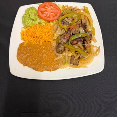 Fajita Plate served with rice, beans, guacamole, pico de gallo and salad.