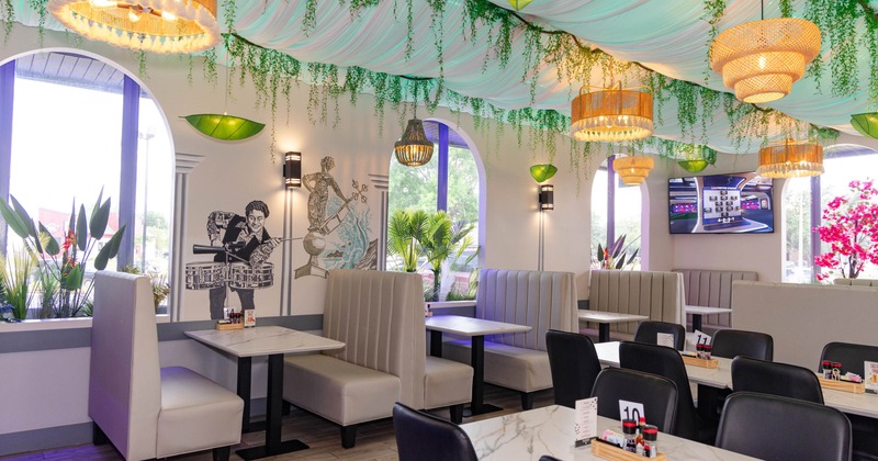 Interior, draped fabric ceiling, lamps, decorative wall art, booth seating, marble tables