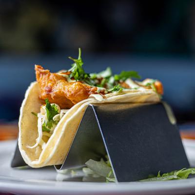 Close-up of a fish taco on a metal holder.