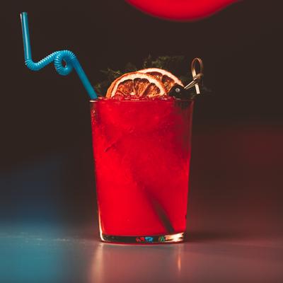 A glass of red cocktail drink