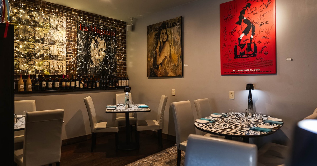 Interior, tables and chairs near wall with pictures