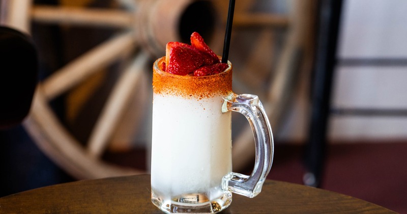 Creamy cocktail in a glass mug with strawberries and chili rim