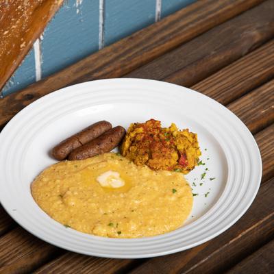 Buttered yellow grits, chickpea scramble and maple sausages on the plate