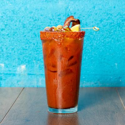 Bloody Mary served with a chili rim and various edible garnishes.