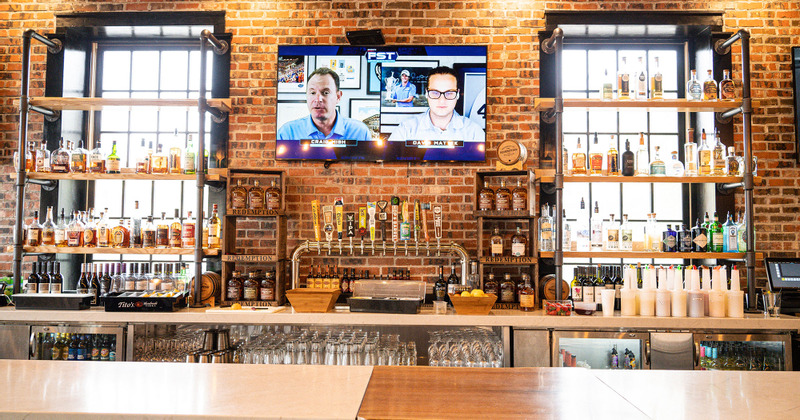 Interior, bar shelves with drink bottles, beer taps and a large wall TV