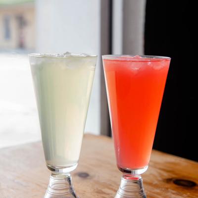 Lemon and strawberry lemonades on a wooden table.