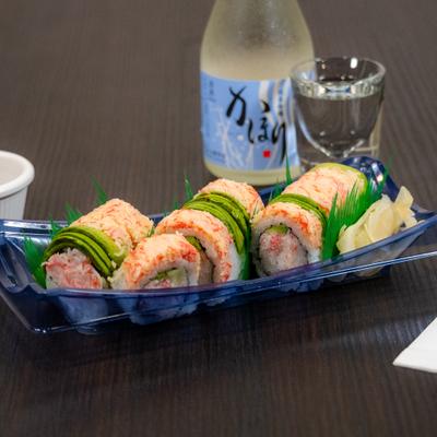 Sushi rolls served with sake bottle and a glass.