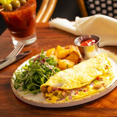 Southwest Omelet served with arugula salad, ketchup, and potatoes.