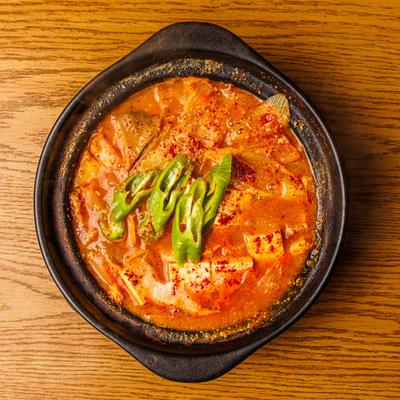 Soybean paste stew with tofu, pork, potatoes, and peppers.