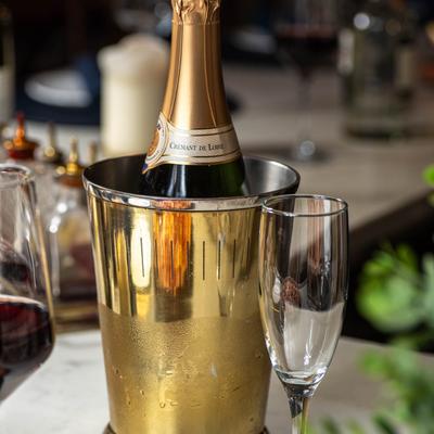 Sparkling wine served on a table with food dishes, close up.