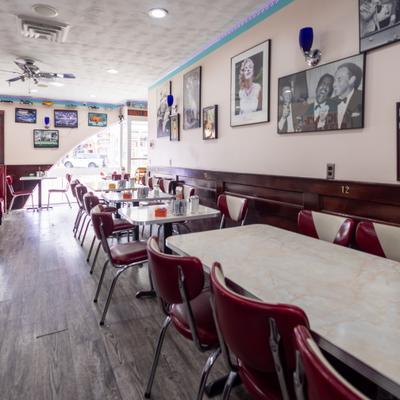 Diner seating area with the walls decorated with framed nostalgia themed photographs.