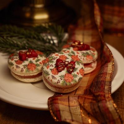 Holiday macarons with floral icing and ribbon decoration.