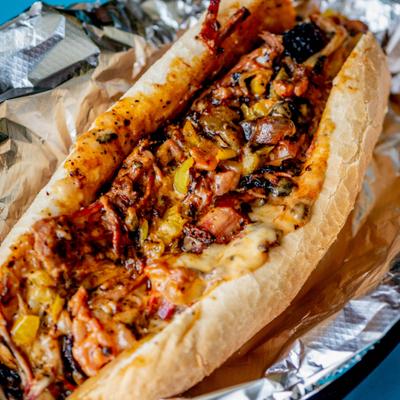 Brisket Cheesesteak served on a hoagie roll and wrapped in aluminum foil.
