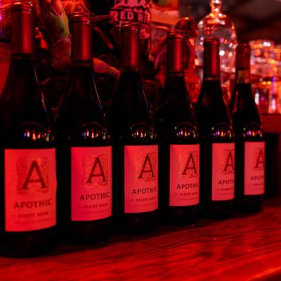 A row of wine bottles on a wooden bar.