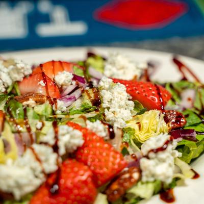 Strawberry salad with greens and crumbled cheese.