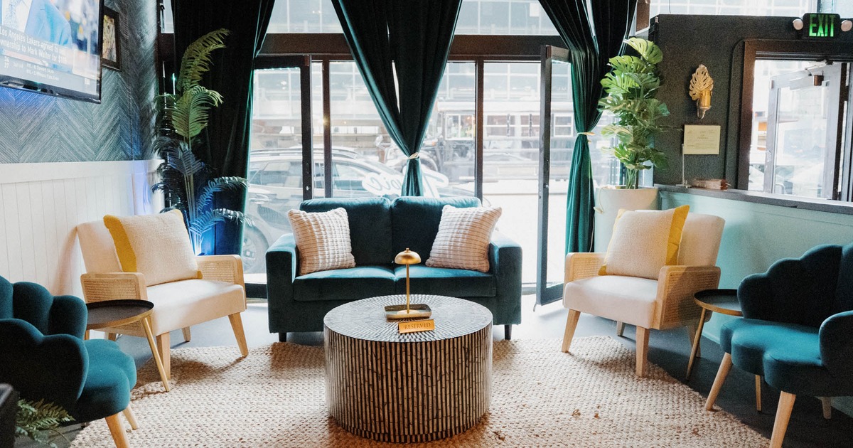 Interior, lounge area,  two seater sofa with armchairs and coffee table, carpet flooring