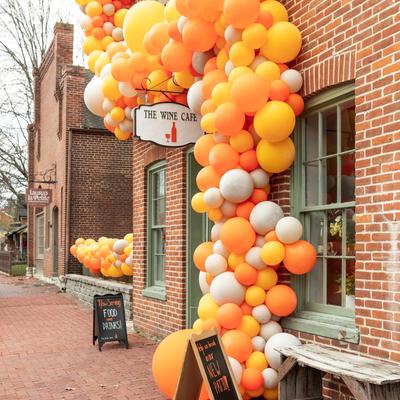 View at the entrance decorated with numereus orange and white ballons.