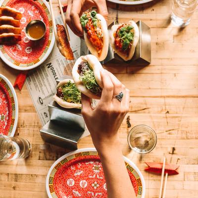 Various food on the table, a customer holding some of it in their hand.
