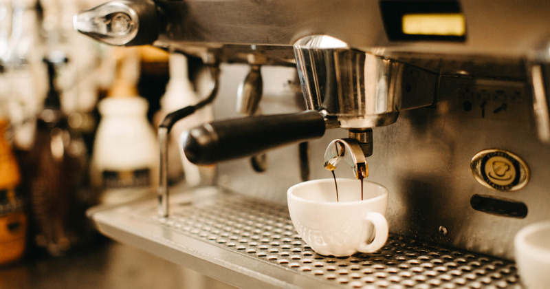 Fresh espresso pouring into a cup from a coffee machine