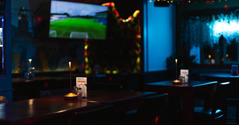 Interior, tables and stools, with TV in the background