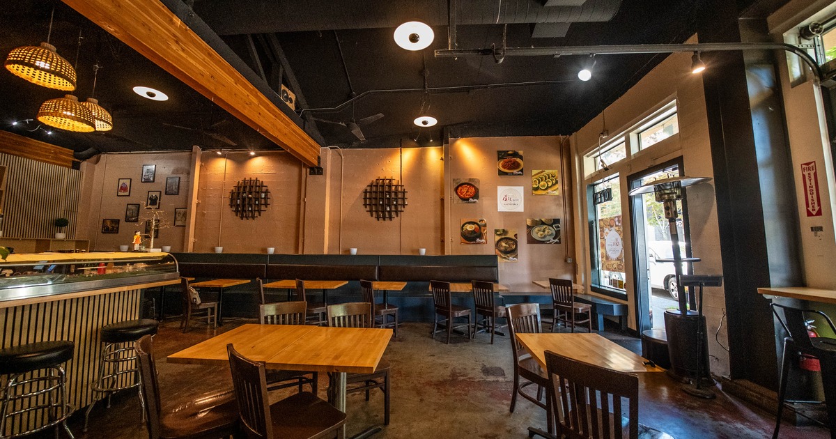 Interior with wooden tables and chairs, pendant lighting and decorative wall elements