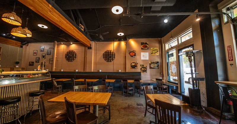 Interior with wooden tables and chairs, pendant lighting and decorative wall elements