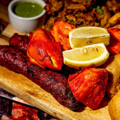 Variety of Indian tandoori dishes, served together as a mixed grill, close-up.