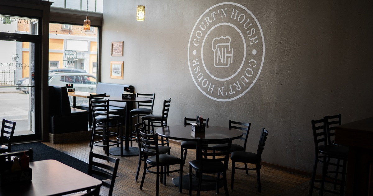Interior, tables, chairs, wall with sign