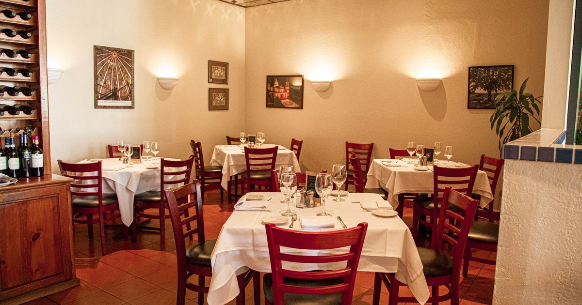 Interior, dining area, white cloth tables for four, ready for guests, tile flooring